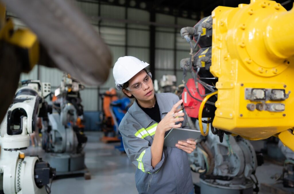 a-female-engineer-installs-a-program-on-a-robotics-arm-in-a-robot-warehouse-1-1-e1706424555548